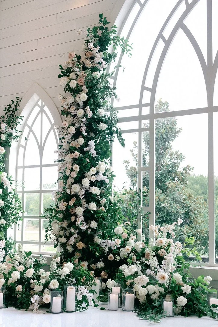 Traditional wedding altar with lush flowers and climbing greenery.jpeg.webp