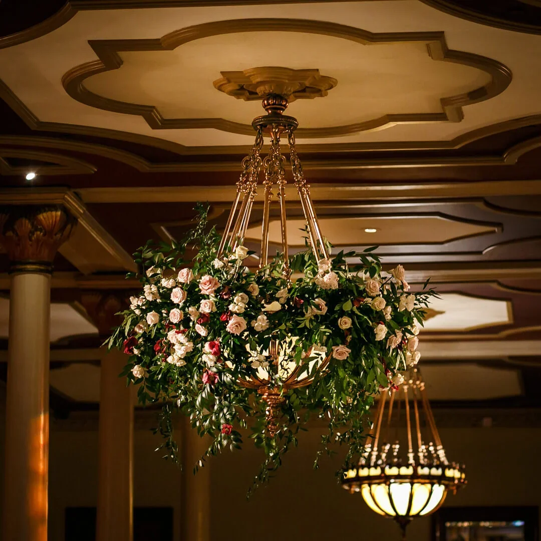 Driskill Hotel flowers and greenery dripping from chandelier wedding.webp