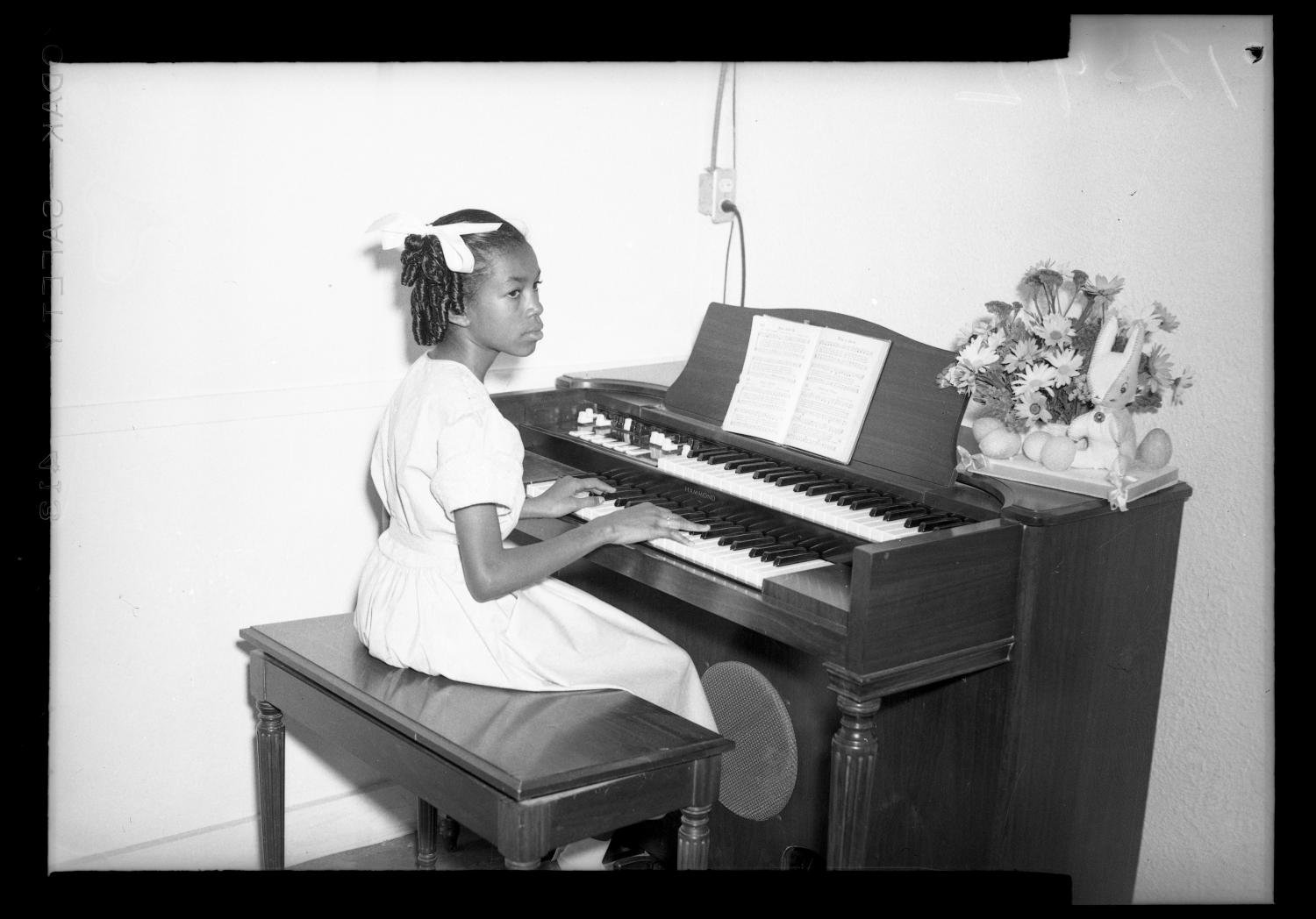 Photograph of a Young Girl Playing a Piano], photograph, Date Unknown