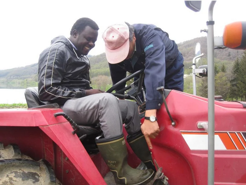 David Nyuol Vincent and Shu Ono (President of Grand Slam) teaching how to use the tractor in a Lavender Farm in South Furano, Japan