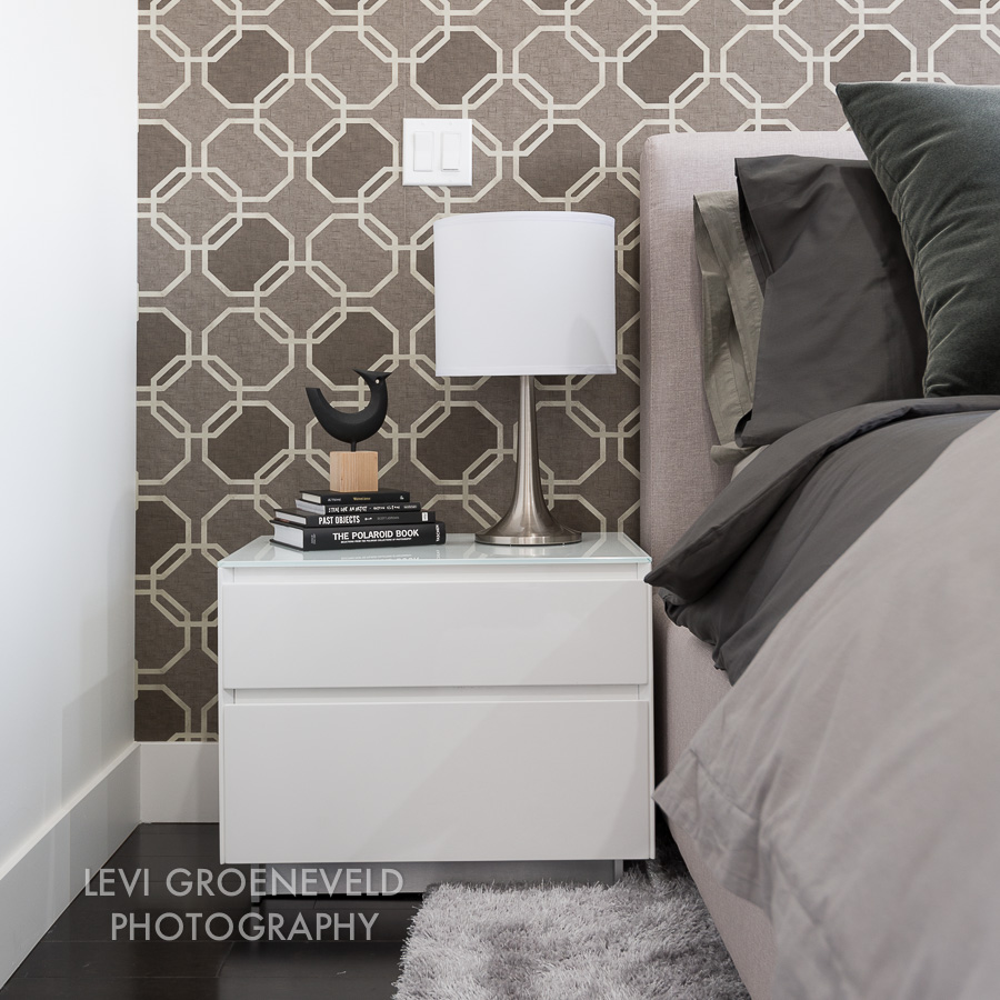 In the master bedroom we used a geometric wall covering as the focal point on the headboard wall. A cozy rug, upholstered headboard and deluxe bedding make for a space that is both comfortable and stylish. 