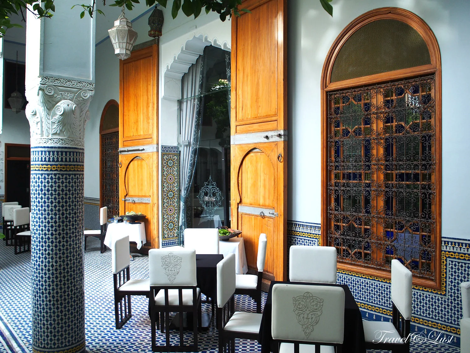 Eden restaurant with zellij tiles, carved woodwork and a view out onto the inner patio.