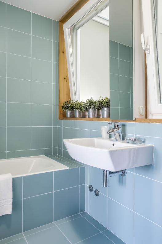 All bathrooms in the building have the same blue tiles and warm character.