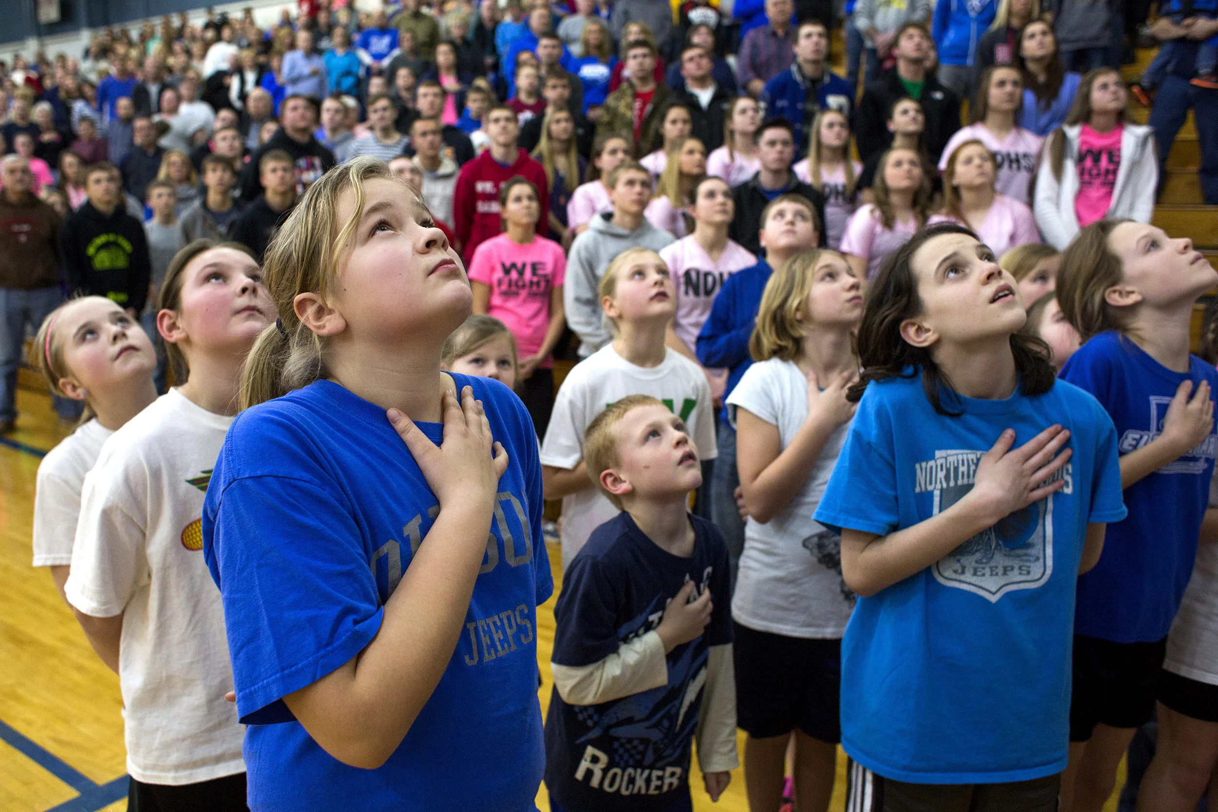  13 Jan. 2015, Dubois, IN -- Gianna Wagner of Celestine, 9, left, look up at the flag for the National Anthem with her schoolmates from Northeast Dubois Elementary School and Celestine Elementary School on Tuesday night in Dubois. The two elementary 