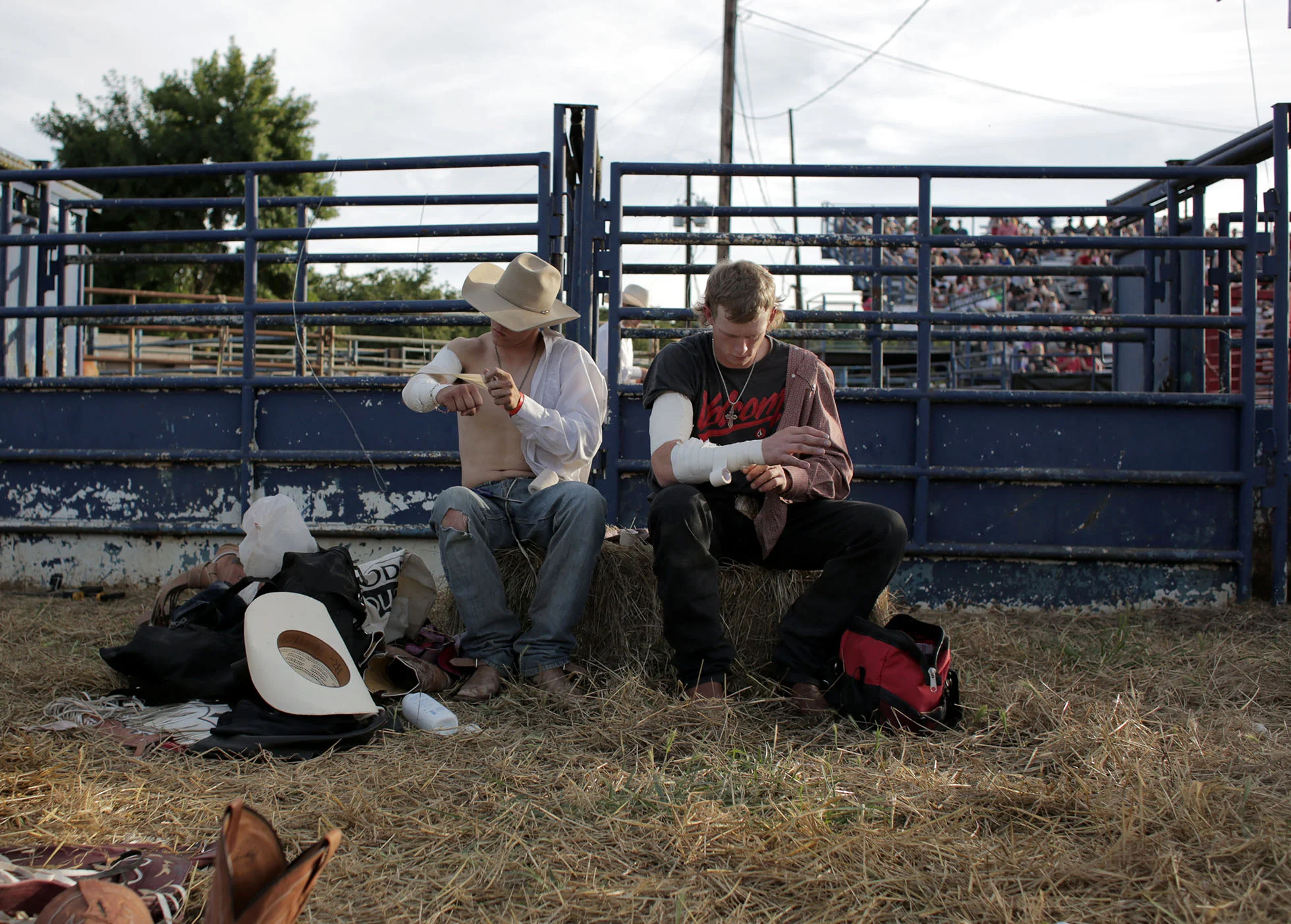  4 July 2014, Eugene, OR --&nbsp;Casey Meroshnekoff of Red Bluff, left, and Wyatt Bloom of Bend, right, tape up their arms to prevent injuries in the bareback riding event at Eugene Pro Rodeo on July 4th at the Oregon Horse Center.&nbsp; (Copyright T