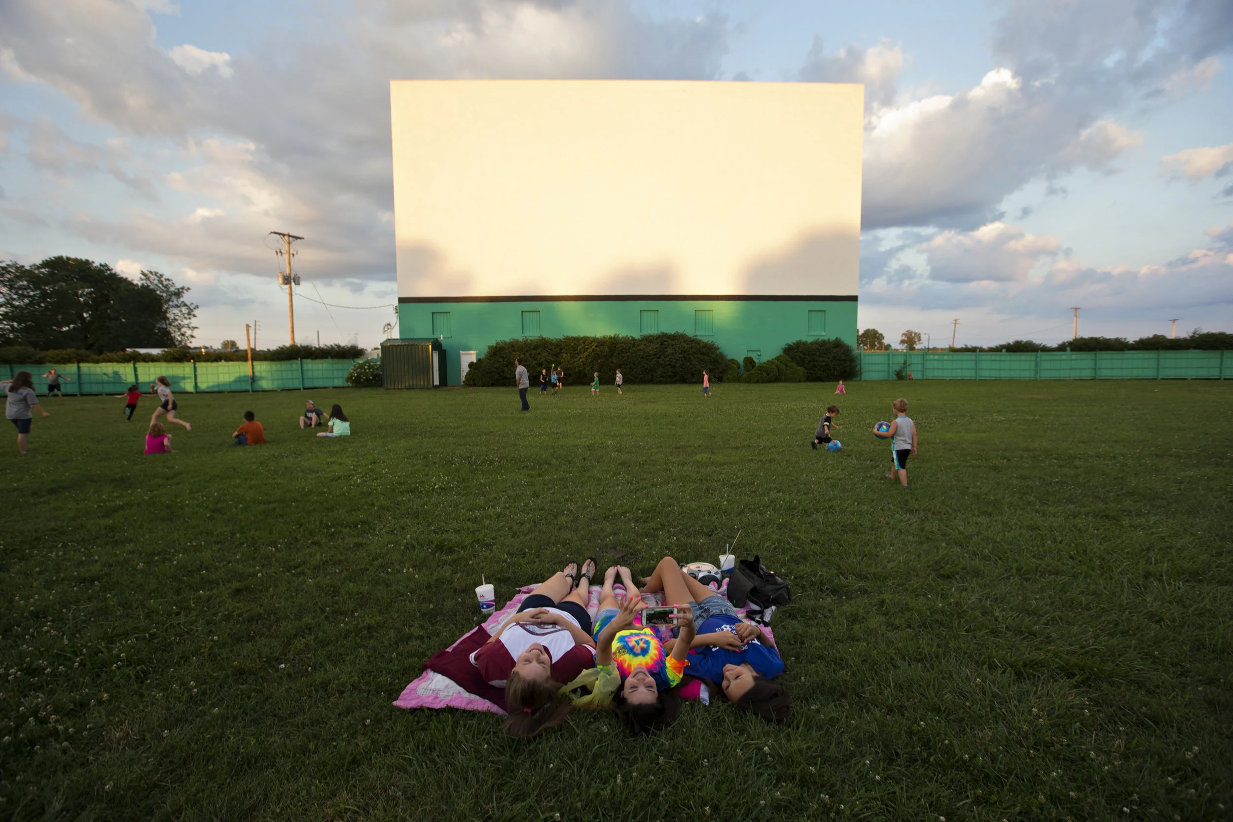  Children dart around the grass under Holiday Drive-In’s main screen as they wait for Finding Dory to begin on June 17. Jules Hubbard held her phone up to take a selfie with friends Trinity Mayes, left, and Bri Kellams, all 14 and of Evansville. It w