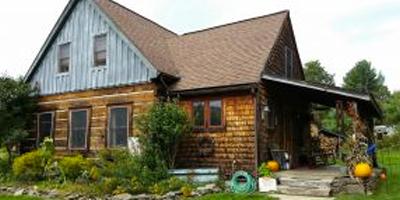 A cozy log cabin-style home on 15 acres with a pond and cabin in the woods.