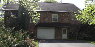 A brick Cape Cod on a corner lot with enchanting gardens.
