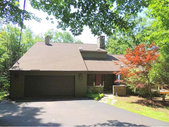 A spacious contemporary nestled in the woods and full of natural light.