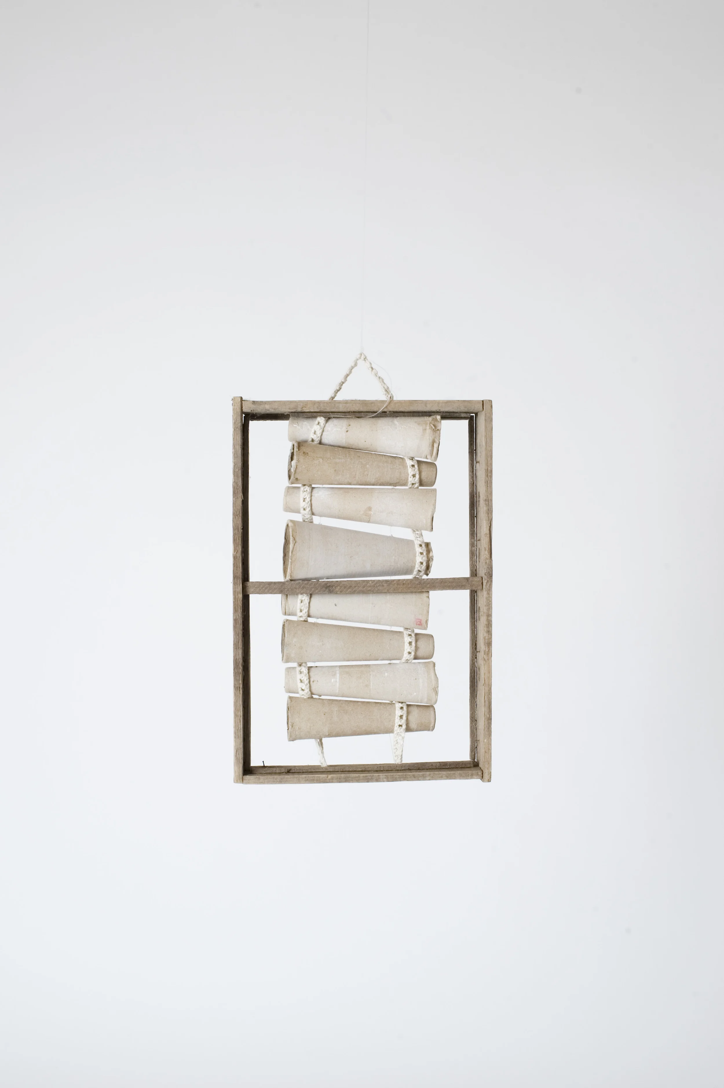 Cardboard spools with crochet dyed yak wool inserted within a reclaimed timber window frame.