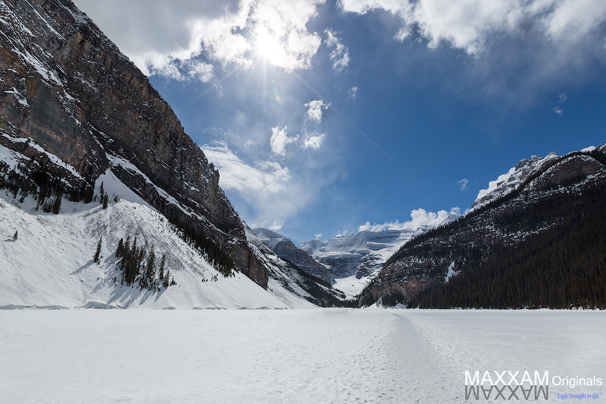 Lake Louise in the early weeks of spring is still frozen over, allowing visitors to walk across what would normally be open water.