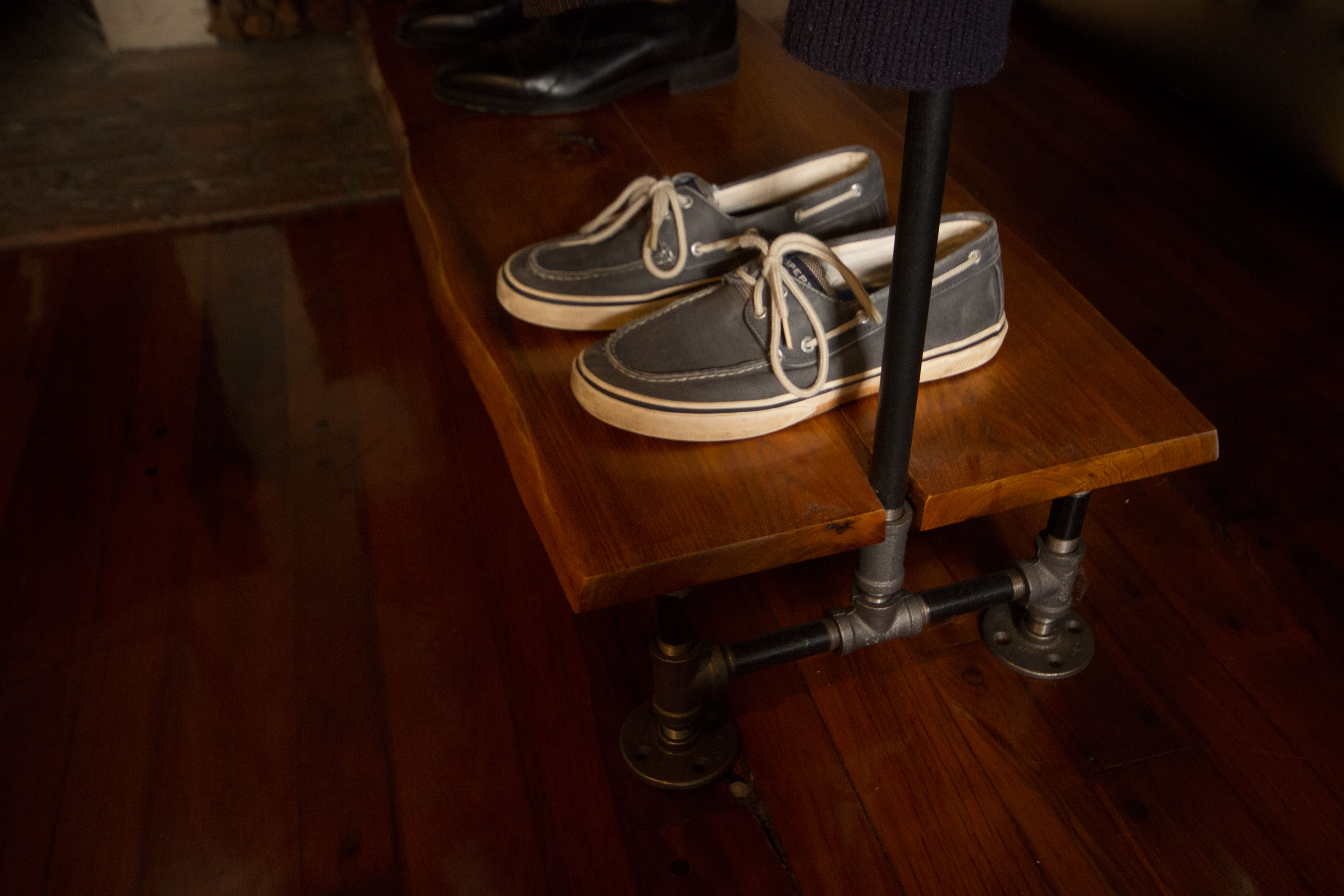 The feet and supporting structure for the shelf and coat rack are made from 1/2" black steel pipe joined with corresponding plumbing parts.