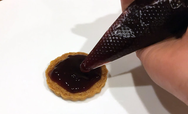 After all your cookies have cooled, pipe your berry jam into the centers.