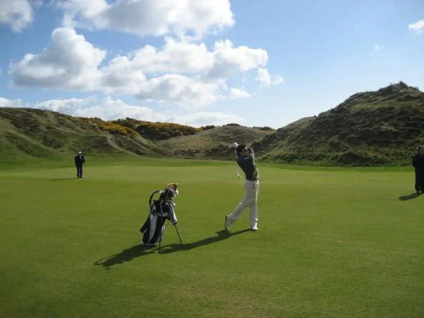 An 18-year old Rory McIlroy sweeps an iron shot off the ninth fairway at Royal County Down. 