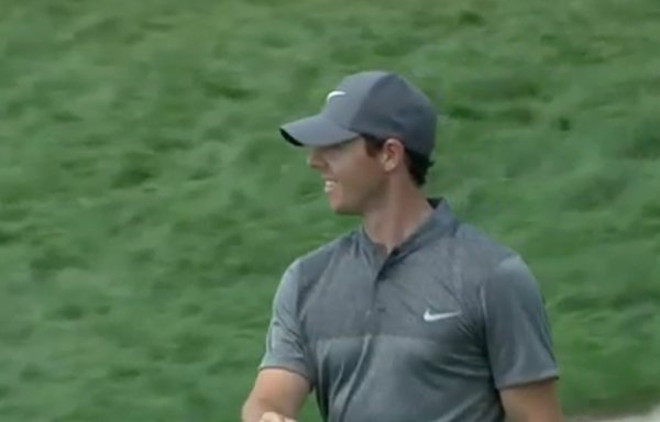 Rory McIlroy smiles after holing a 60 footer at the 18th