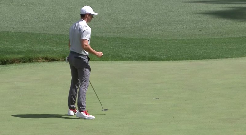Rory McIlroy fist pumps after a crucial birdie putt drops at the 13th