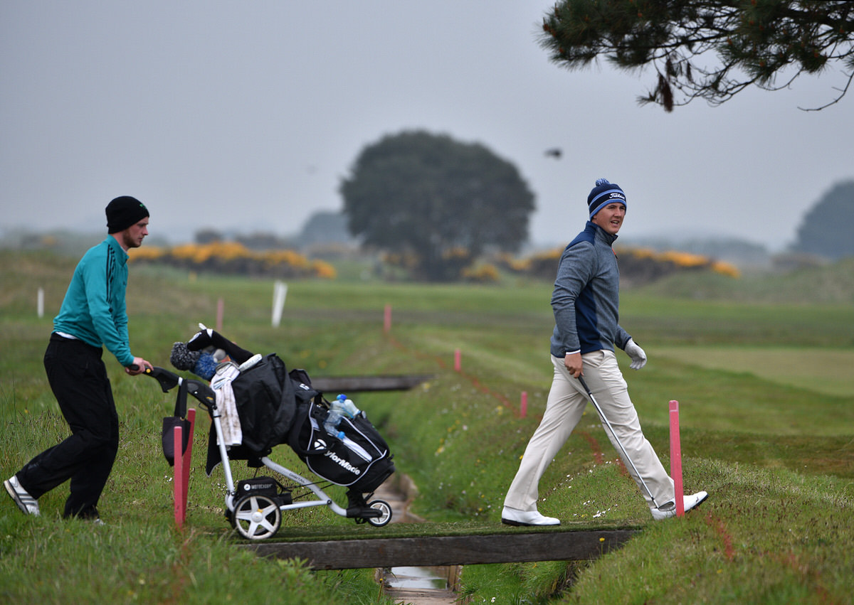 Follow the leader. Colm Campbell (Warrenpoint) walking across the bridge at the 13th hole followed by his caddy Stephen Coulter in the third round of the 2016 Flogas Irish Amateur Open Championship at The Royal Dublin Golf Club. Picture by Pat Cashman