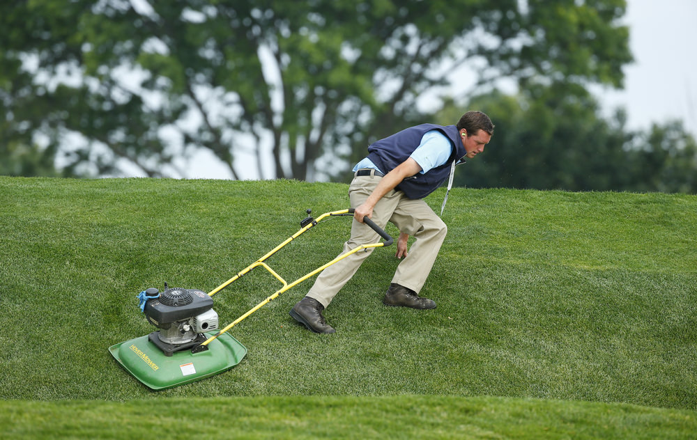 A grounds crew member mows grass during a practice round for the 2016 U.S. Open at Oakmont Country Club in Oakmont, Pa. on Wednesday, June 15, 2016. (Copyright USGA/Jeff Haynes)