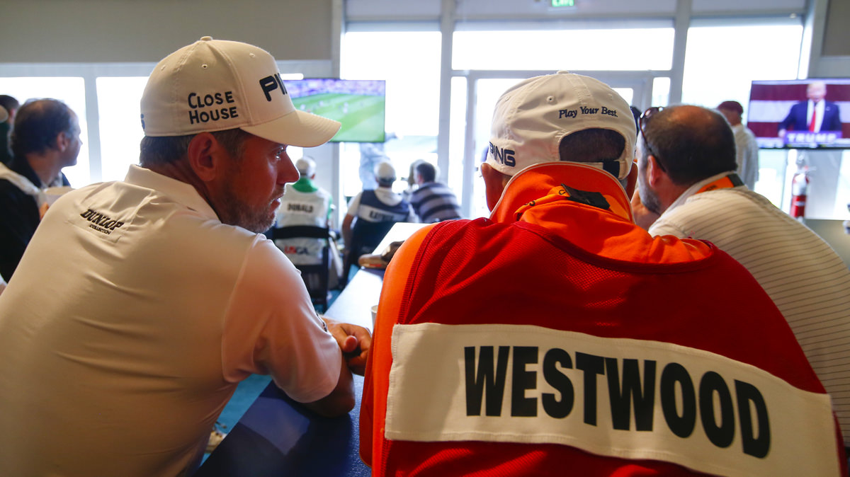 Lee Westwood and his caddie, Billy Foster, sit in the media dining room to watch the England versus Wales soccer game on TV while in a rain delay during the first round for the 2016 U.S. Open at Oakmont Country Club. Copyright USGA/Jeff Haynes
