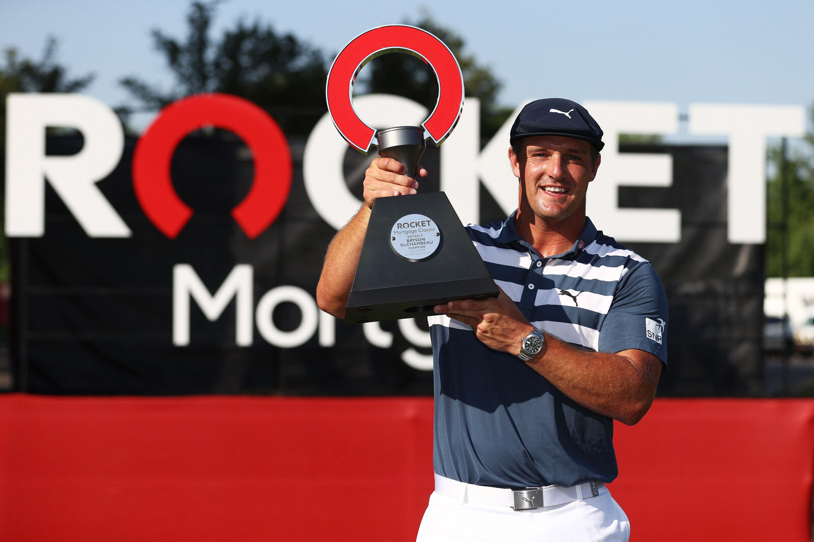  DETROIT, MICHIGAN - JULY 05: Bryson DeChambeau of the United States celebrates with the trophy after winning during the final round of the Rocket Mortgage Classic on July 05, 2020 at the Detroit Golf Club in Detroit, Michigan. (Photo by Gregory Sham