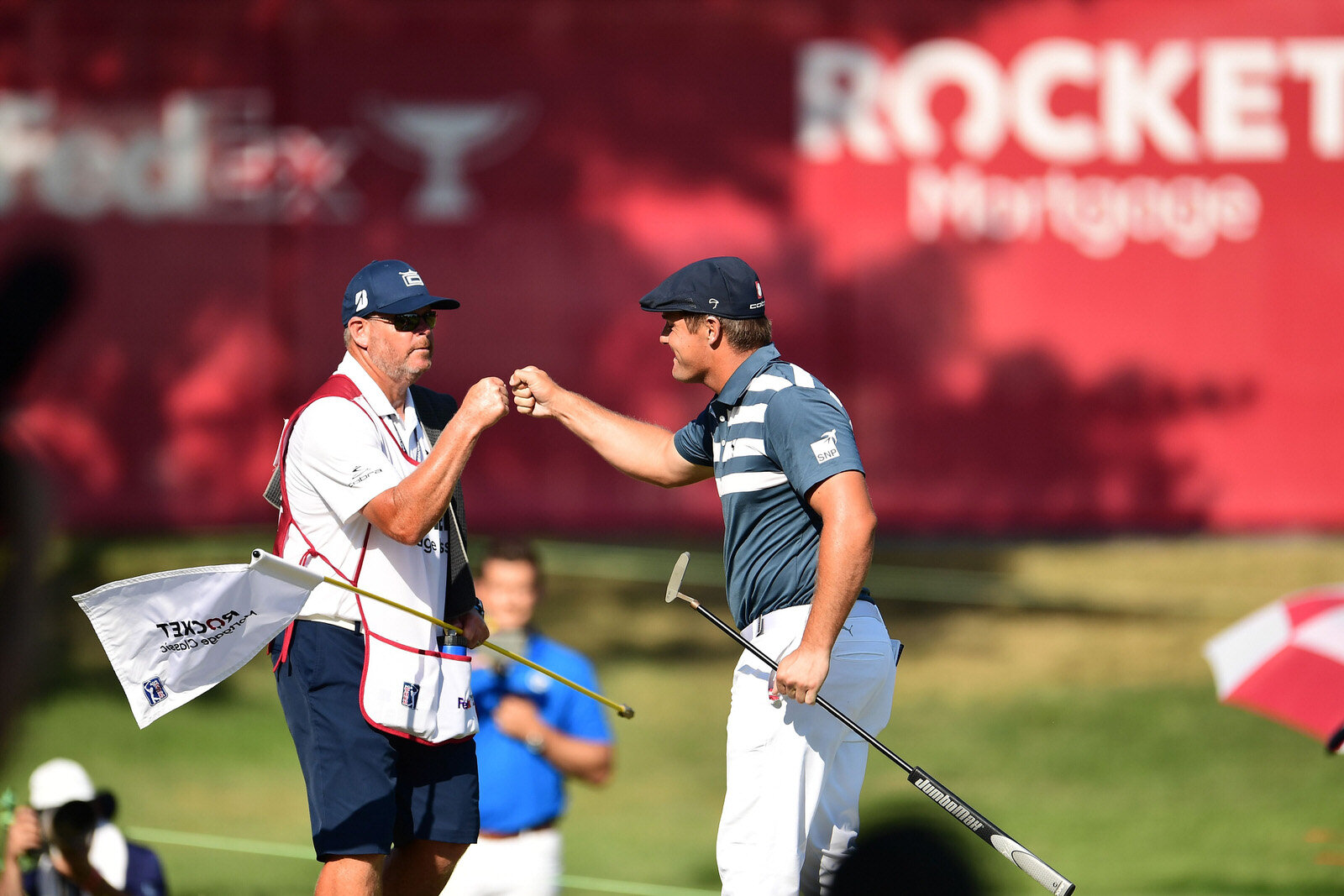  DETROIT, MICHIGAN - JULY 05: Bryson DeChambeau of the United States and caddie Tim Tucker celebrate on the 18th green on his way to winning during the final round of the Rocket Mortgage Classic on July 05, 2020 at the Detroit Golf Club in Detroit, M