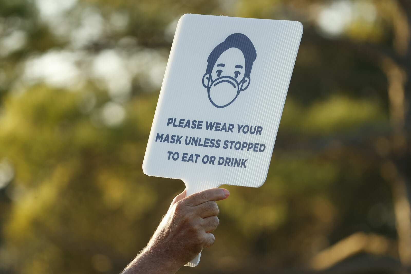  HOUSTON, TEXAS - NOVEMBER 05: A volunteer holds a sign encouraging fans to keep their masks on during the first round of the Vivint Houston Open at Memorial Park Golf Course on November 05, 2020 in Houston, Texas. (Photo by Maddie Meyer/Getty Images