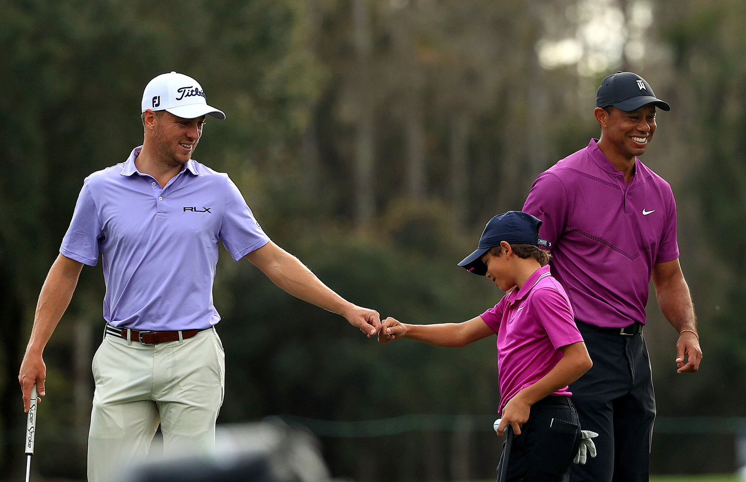  ORLANDO, FLORIDA - DECEMBER 19: Tiger Woods of the United States' son Charlie Woods high five Justin Thomas of the United States on the ninth hole during the first round of the PNC Championship at the Ritz Carlton Golf Club on December 19, 2020 in O