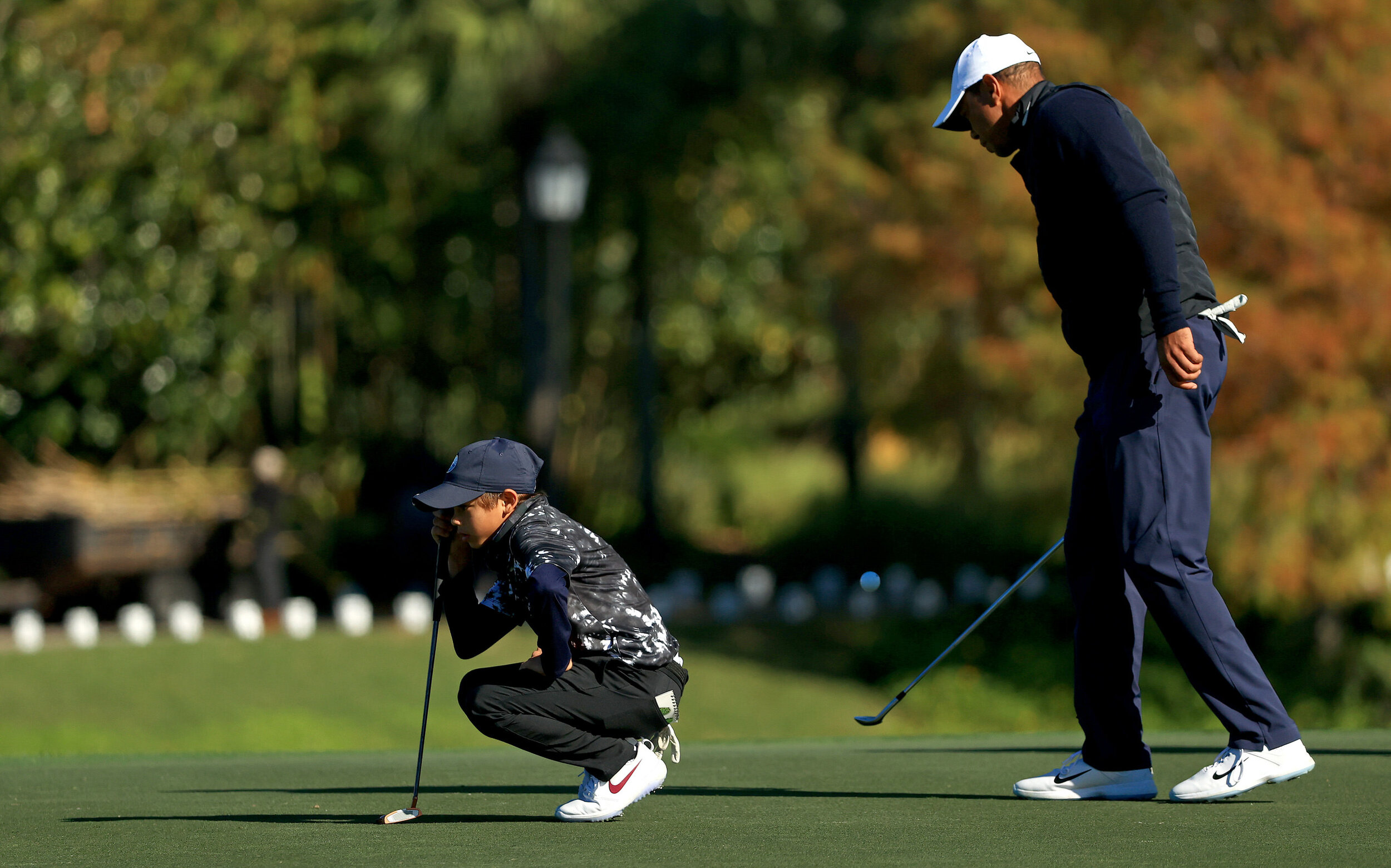  ORLANDO, FLORIDA - DECEMBER 18: Tiger Woods of the United States and son Charlie Woods line up a putt on the 18th hole during the Pro-Am for the PNC Championship at the Ritz Carlton Golf Club on December 18, 2020 in Orlando, Florida. (Photo by Mike 