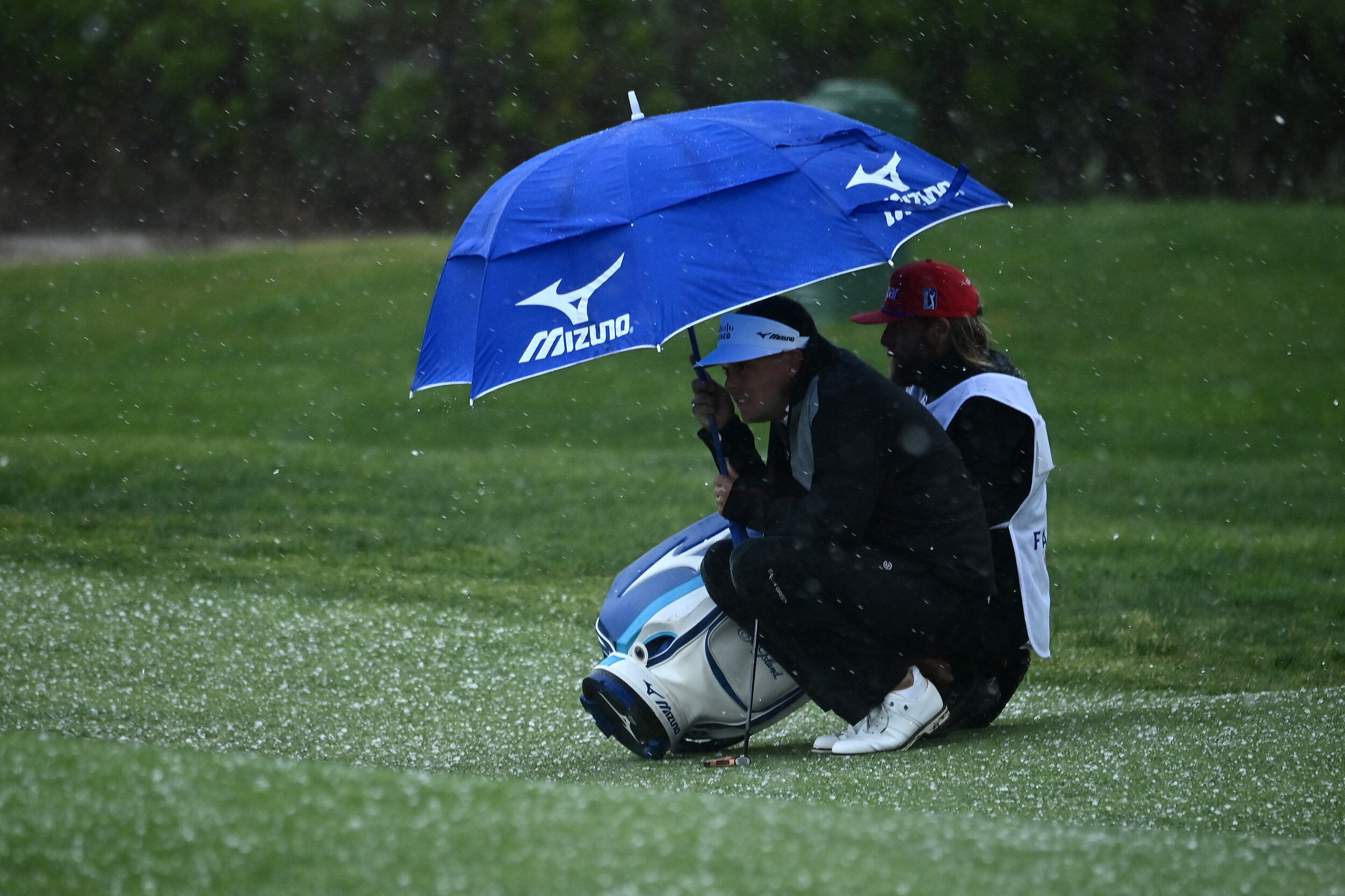  SAN DIEGO, CALIFORNIA - JANUARY 29: Keith Mitchell huddles with his caddie as a hailstorm hits the course during round two of the Farmers Insurance Open at Torrey Pines on January 29, 2021 in San Diego, California. (Photo by Donald Miralle/Getty Ima