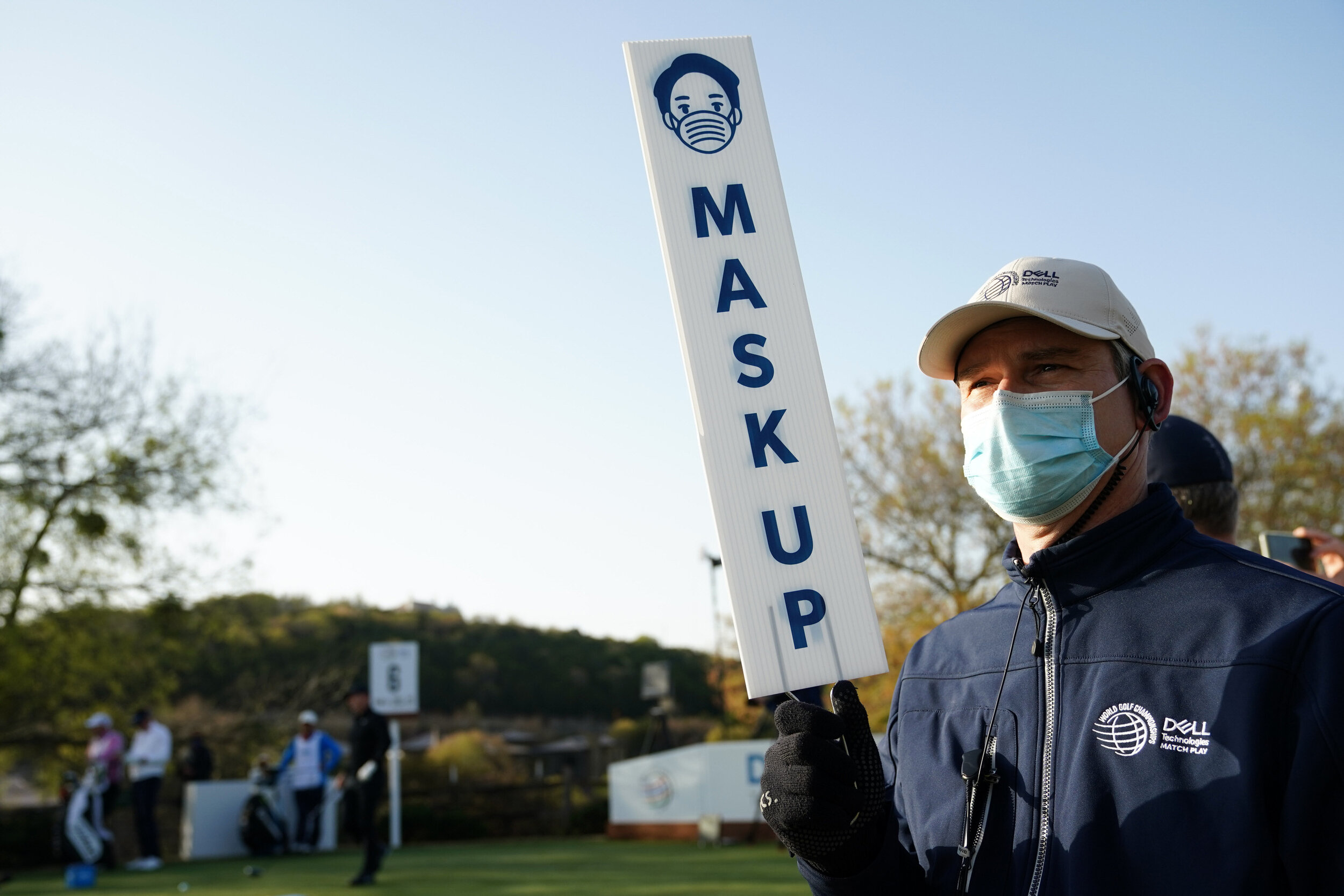  AUSTIN, TEXAS - MARCH 24: A tournament official holds up a "mask up" sign on the sixth hole during the first round of the World Golf Championships-Dell Technologies Match Play at Austin Country Club on March 24, 2021 in Austin, Texas. (Photo by Darr