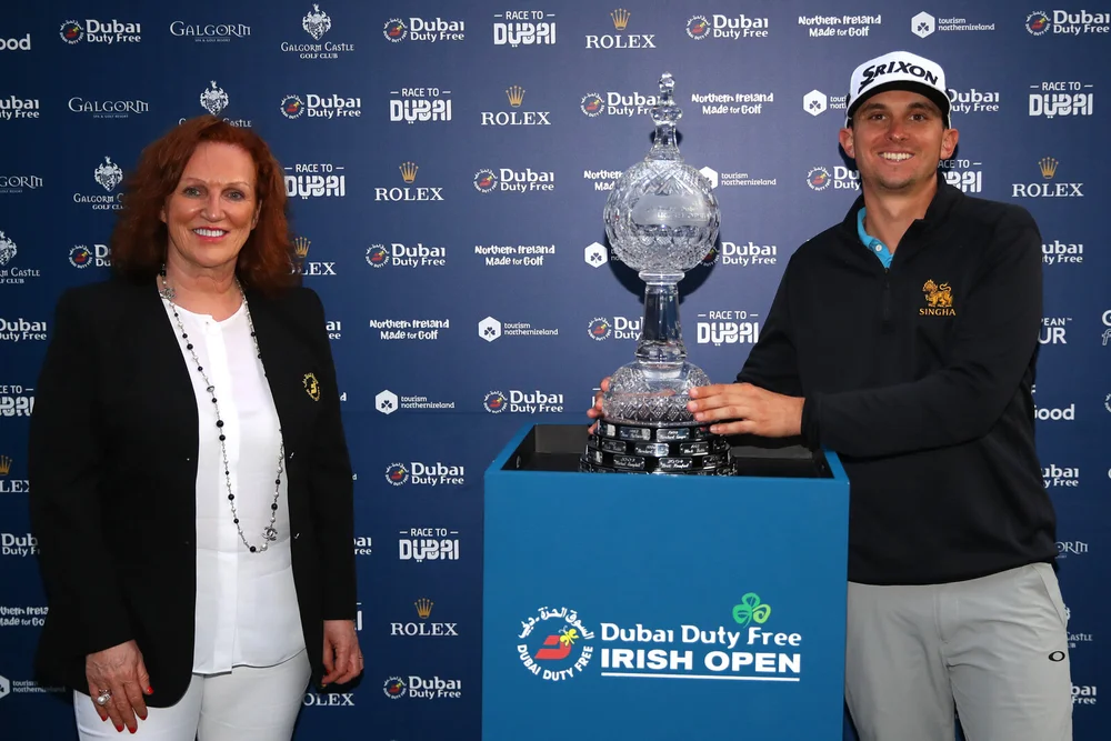BALLYMENA, NORTHERN IRELAND - SEPTEMBER 27: John Catlin of the United States receives the trophy from Sinead El Sibai, Dubai Duty Free Senior Vice President of Marketing. (Photo by Warren Little/Getty Images)