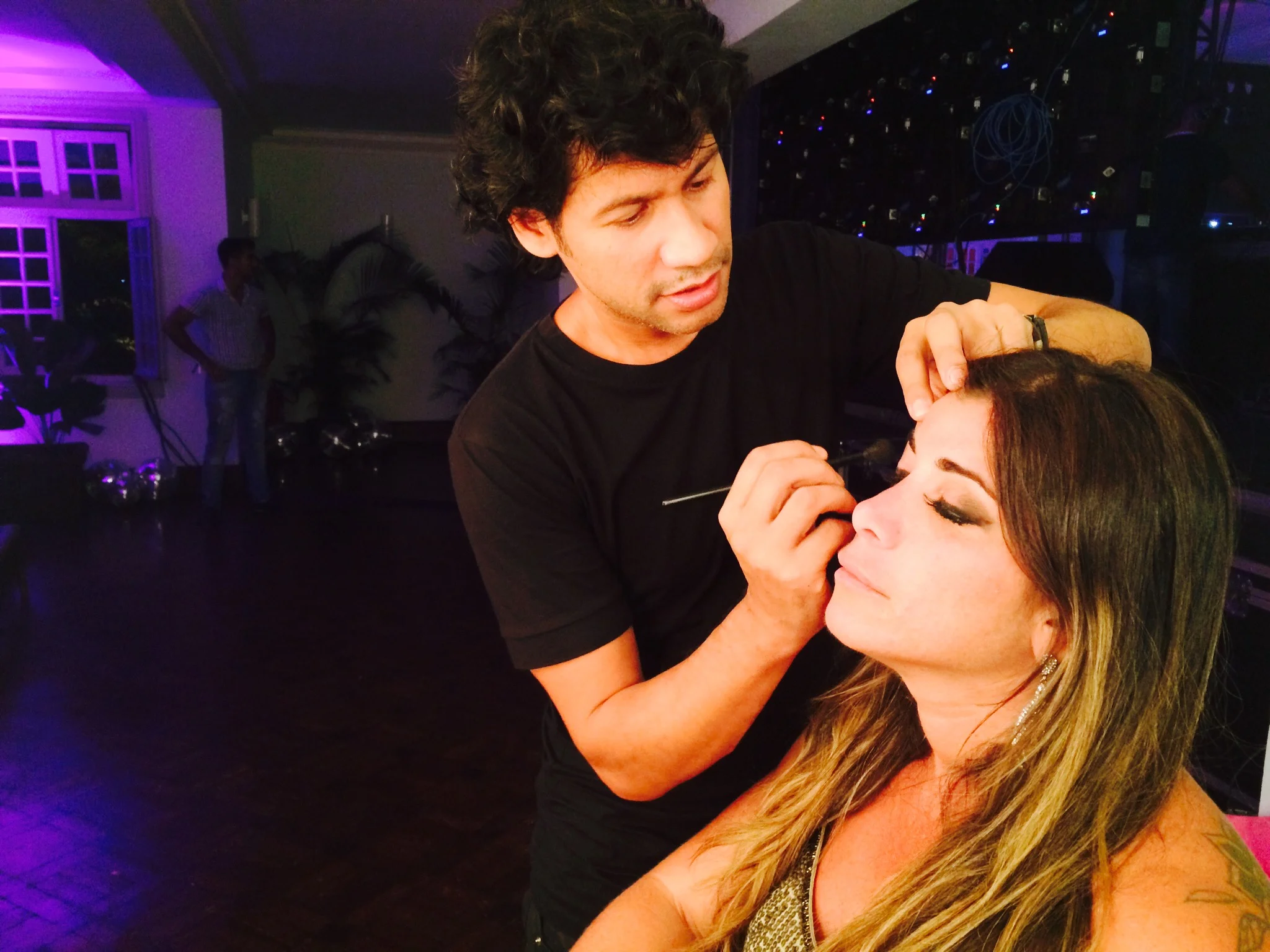 lucas maquiando fernanda tuxi, a produtora da festa