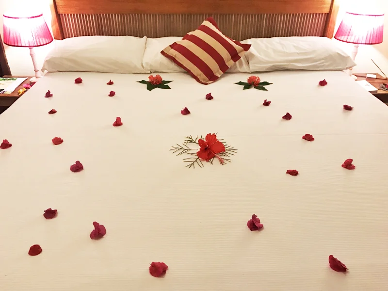 O cuidado na hora de fazer a cama: muitas flores naturais para enfeitar sua estadia