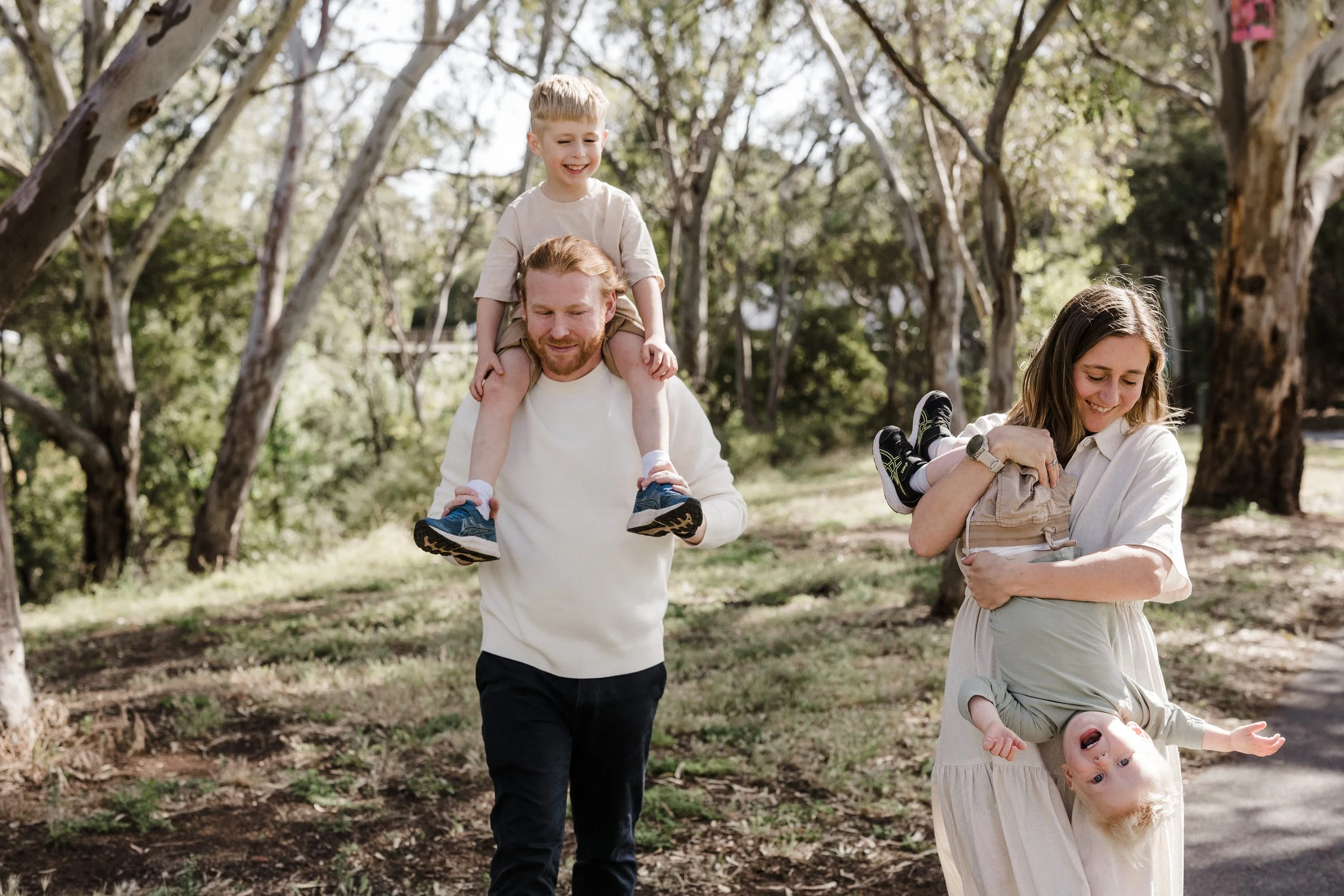 A professional family photograph of a family walking together and interacting naturally. The outfits are relaxed with a complimentary palette.