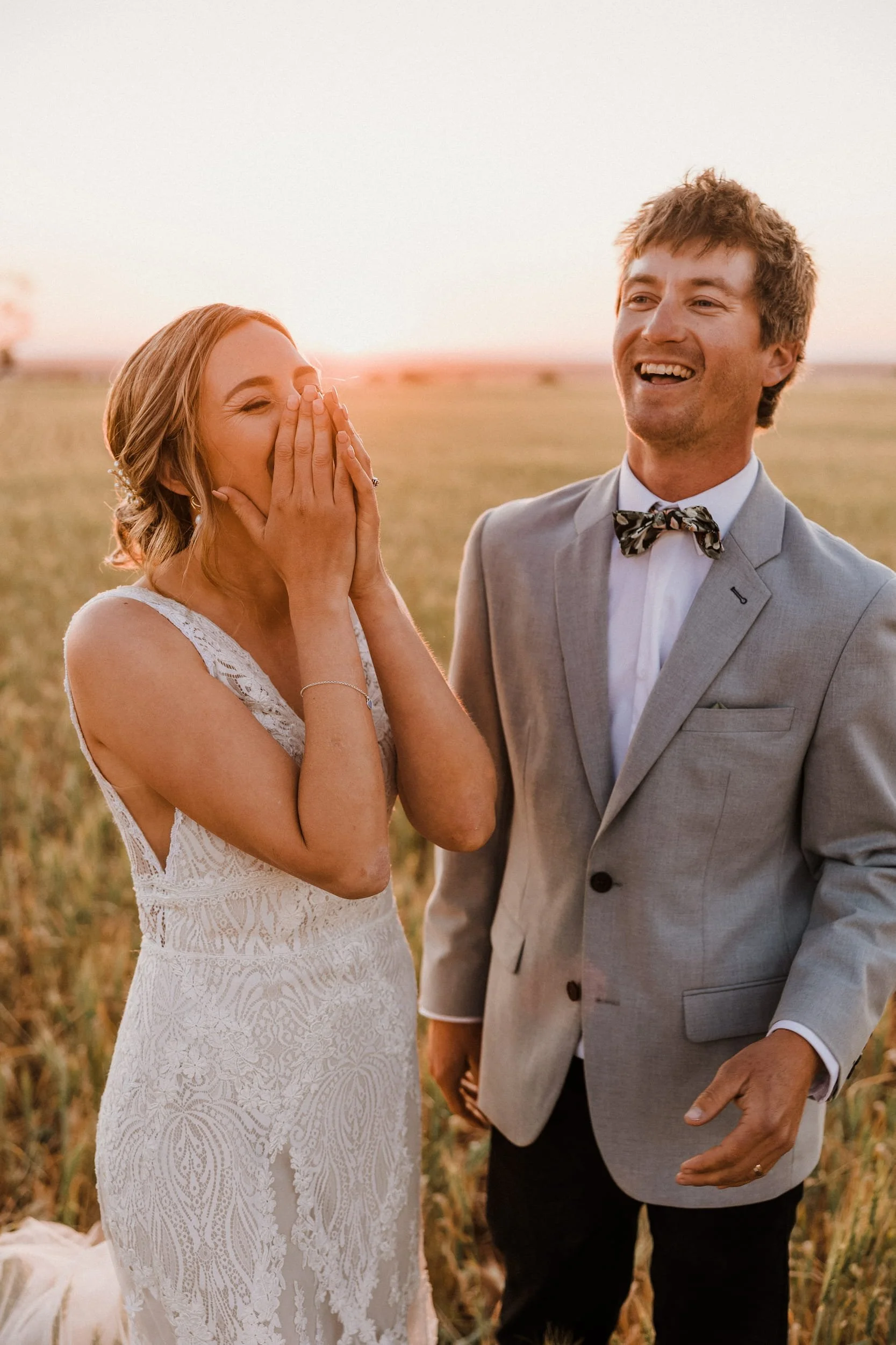 a candid wedding photo of a bride and groom enjoying their wedding portraits at sunset