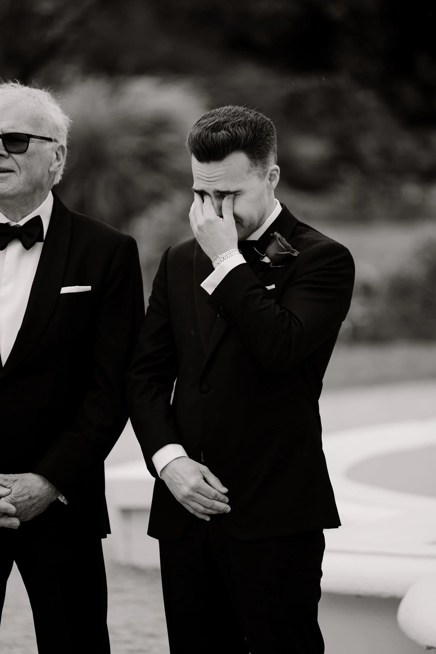 A candid photograph of a groom crying as his bride walks down the aisle in the Adelaide Botanic Gardens