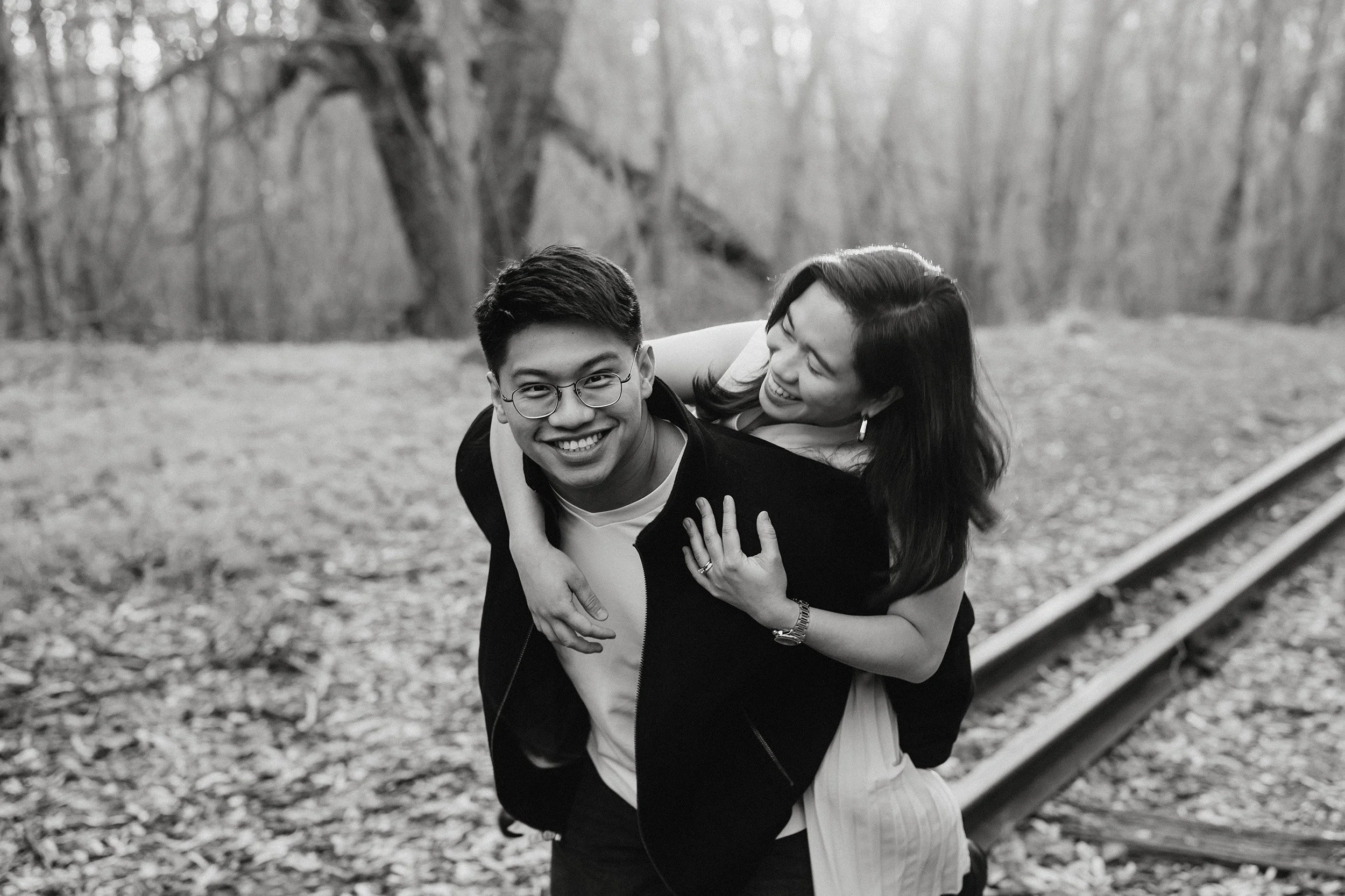 Professional engagement portrait photograph of a man giving a woman a piggy back. The outfits strike a balance between relaxed and elevated.
