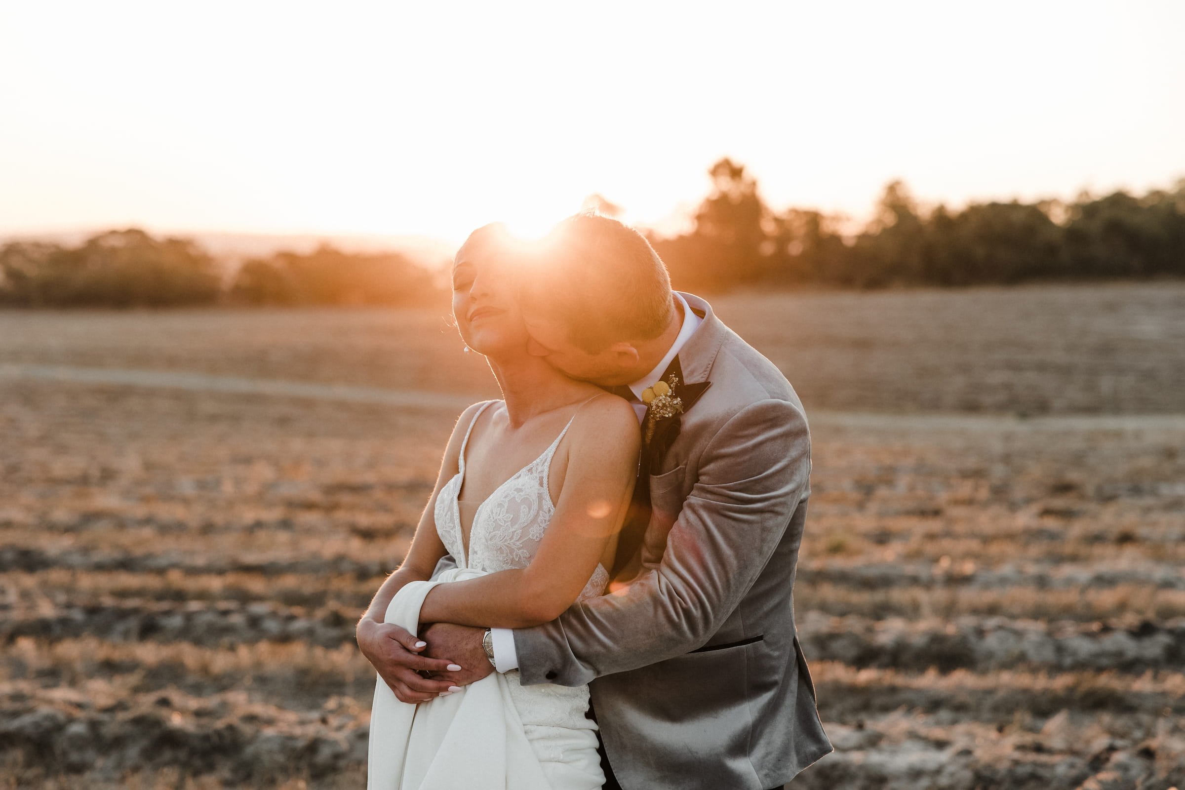 A bride and groom embrace during golden hour, a wedding photograph captured in South Australia by Little Car Photography