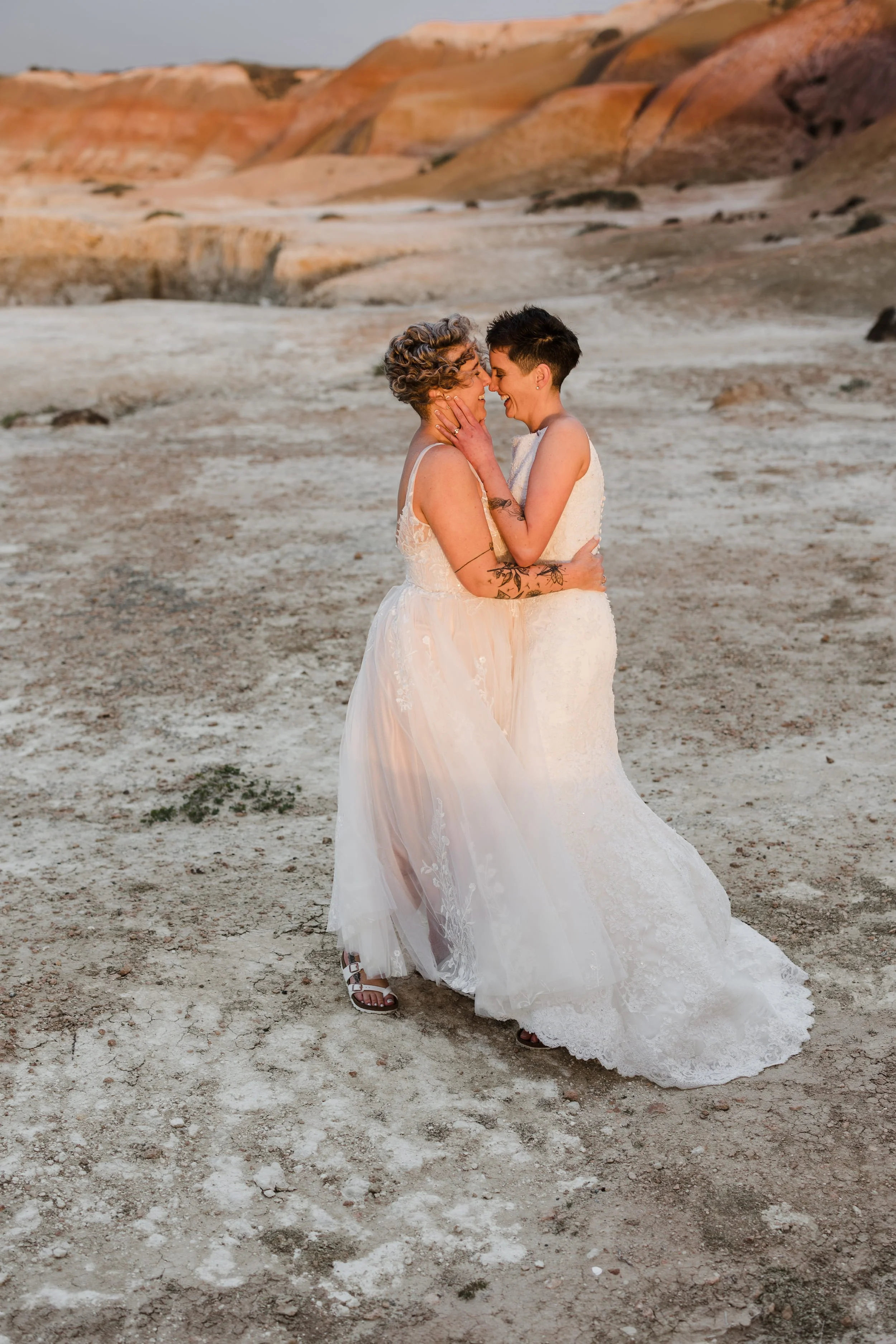 two brides embracing on the port willunga cliffs during the wedding portraits