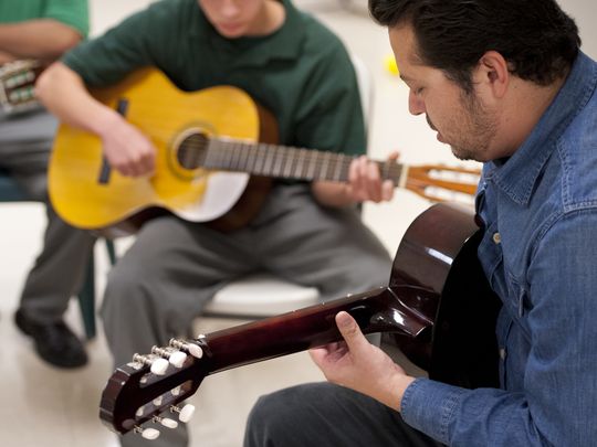 Carlos Rodriguez of Mezcal teaches guitar to youth at Tulare County Probation Youth Facility on Monday, December 14, 2015. Students must behave in and out of all classes to participate in the extracurricular activity. (Photo: Ron Holman)