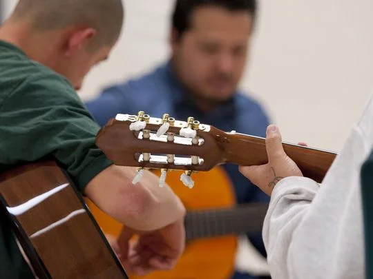 Youth at Tulare County Probation Youth Facility learn guitar from Carlos Rodriguez of Mezcal on Monday, December 14, 2015. Students must behave in and out of all classes to participate in the extracurricular activity. (Photo: Ron Holman)