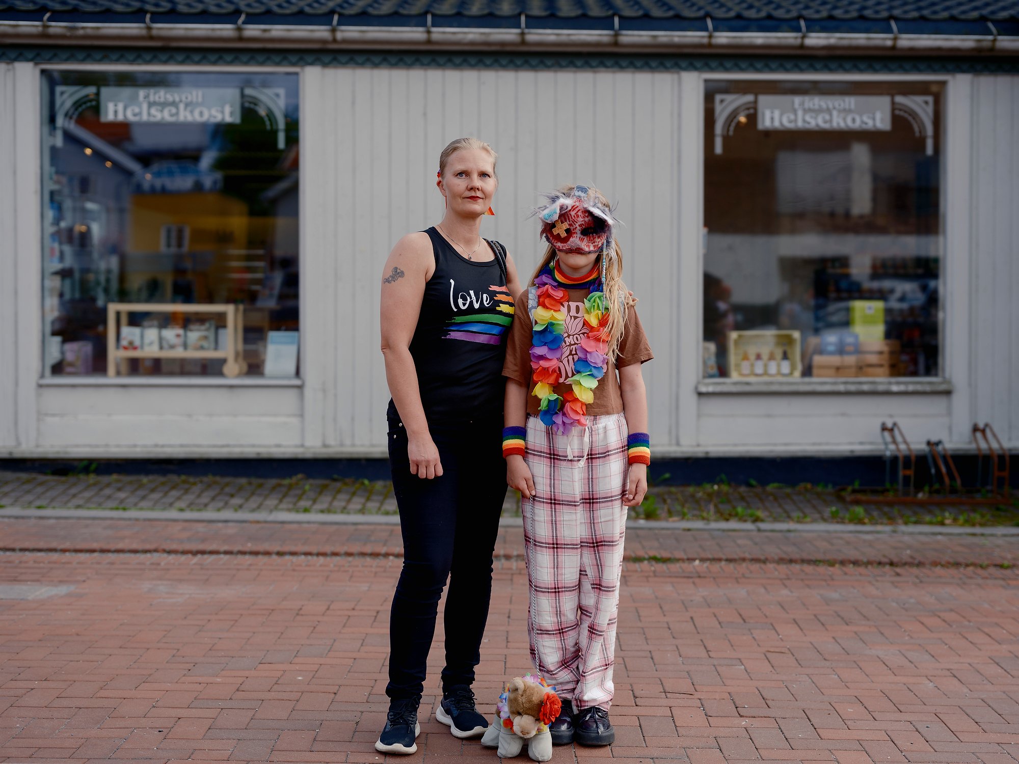  Linda  and her daughter Isabelle, 11, outside Eidsvoll Helsekost after the local Pride parade, Eidsvoll, June 2026.  