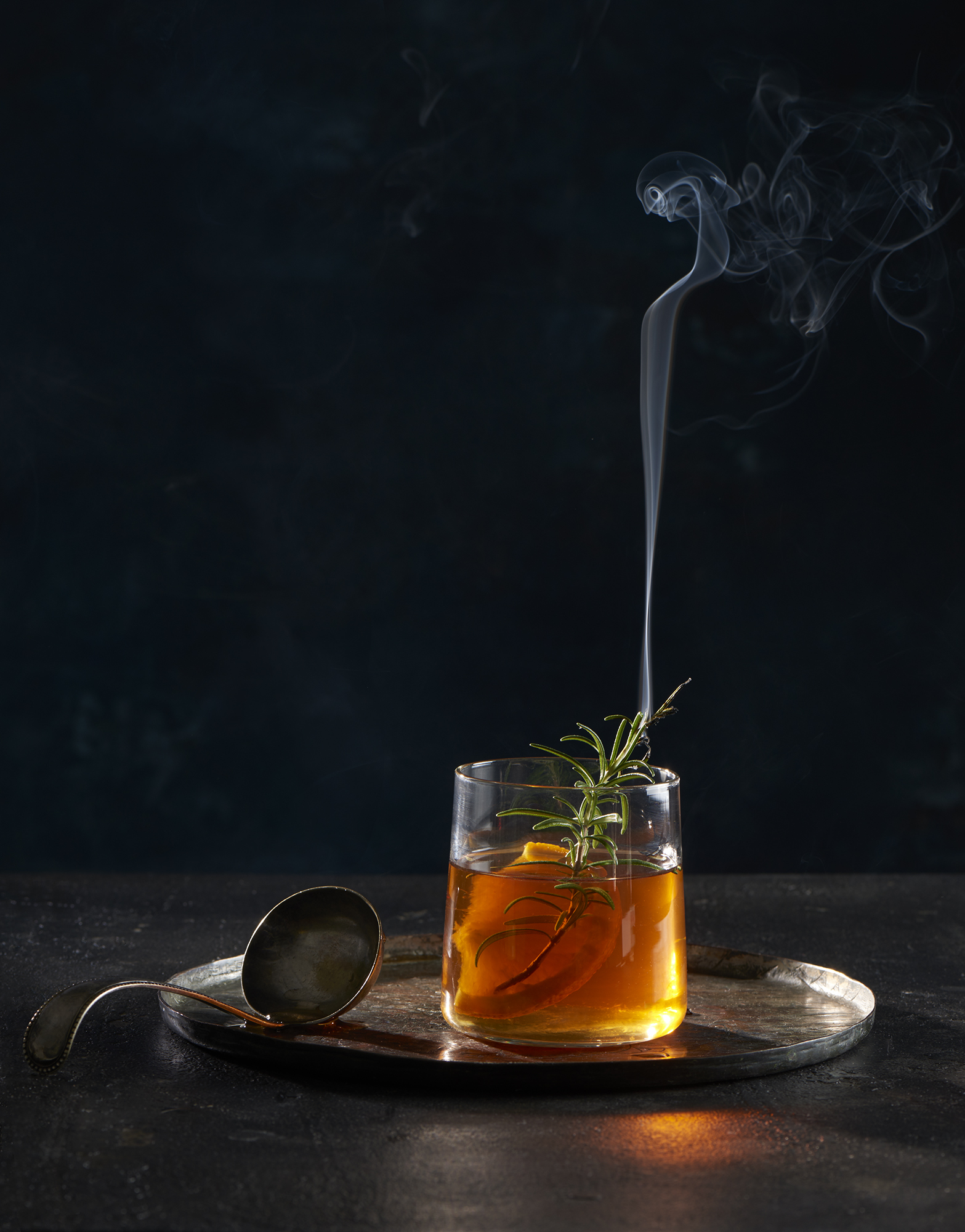 Mulled punch with orange and smoking rosemary garnish. Props styling by Tamsin Weston