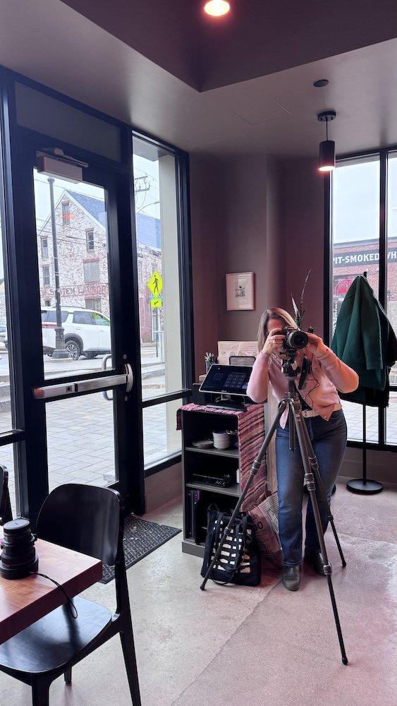 a photo of a photographer and her tripod at a restaurant photoshoot