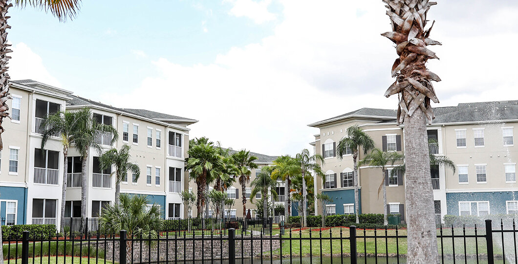 grey and aqua colored apartment building with palm trees