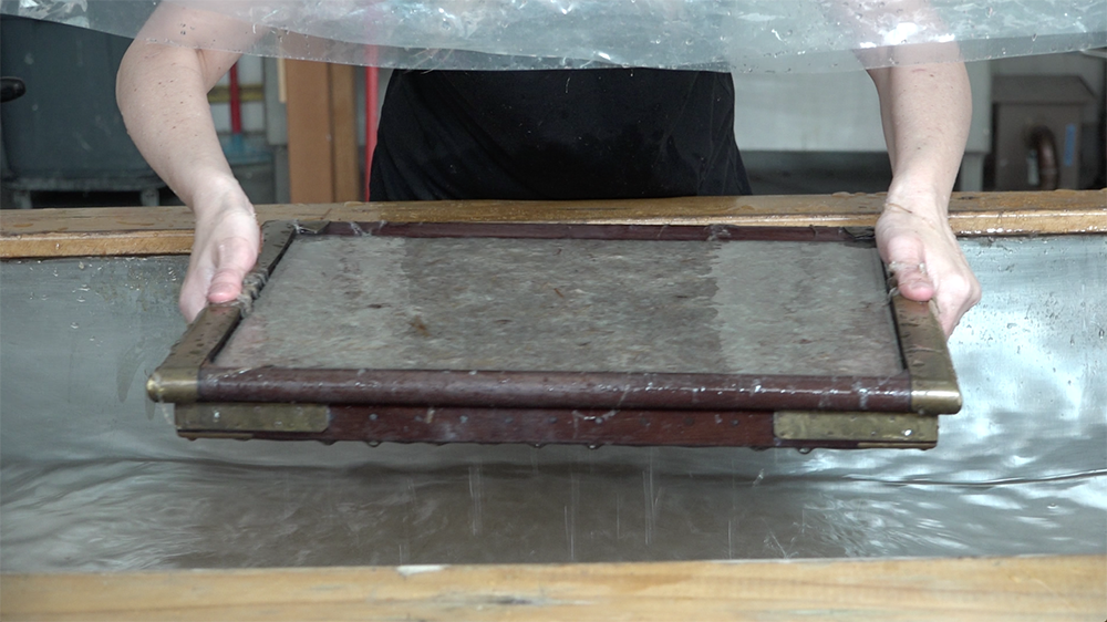   Pulling paper with a mould used by Marilyn Sward in the 80s at her organization, Paper Press.  