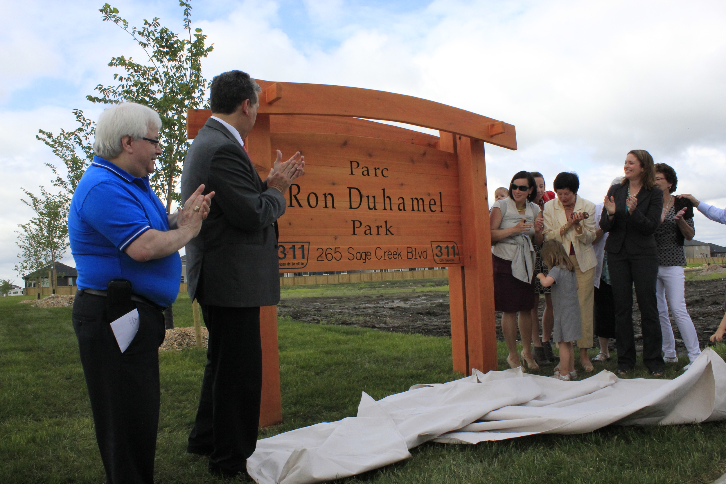 Left to Right - SCRA President Frank Capasso, Councillor Dan Vandal, the Duhamel family, and MLA Erin Selby take part in the unveiling of the Parc Ron Duhamel Park sign.