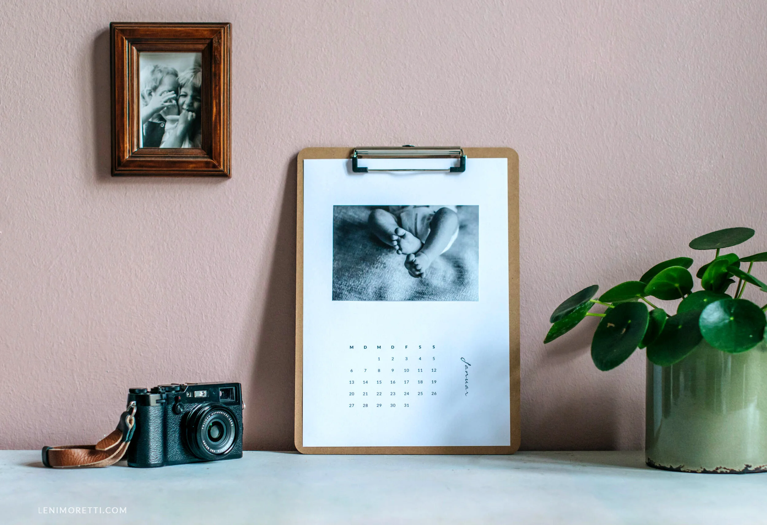 Ausgedruckte Fotokalender Vorlage 2027 mit aufgeklebtem Foto auf einem Klemmbrett