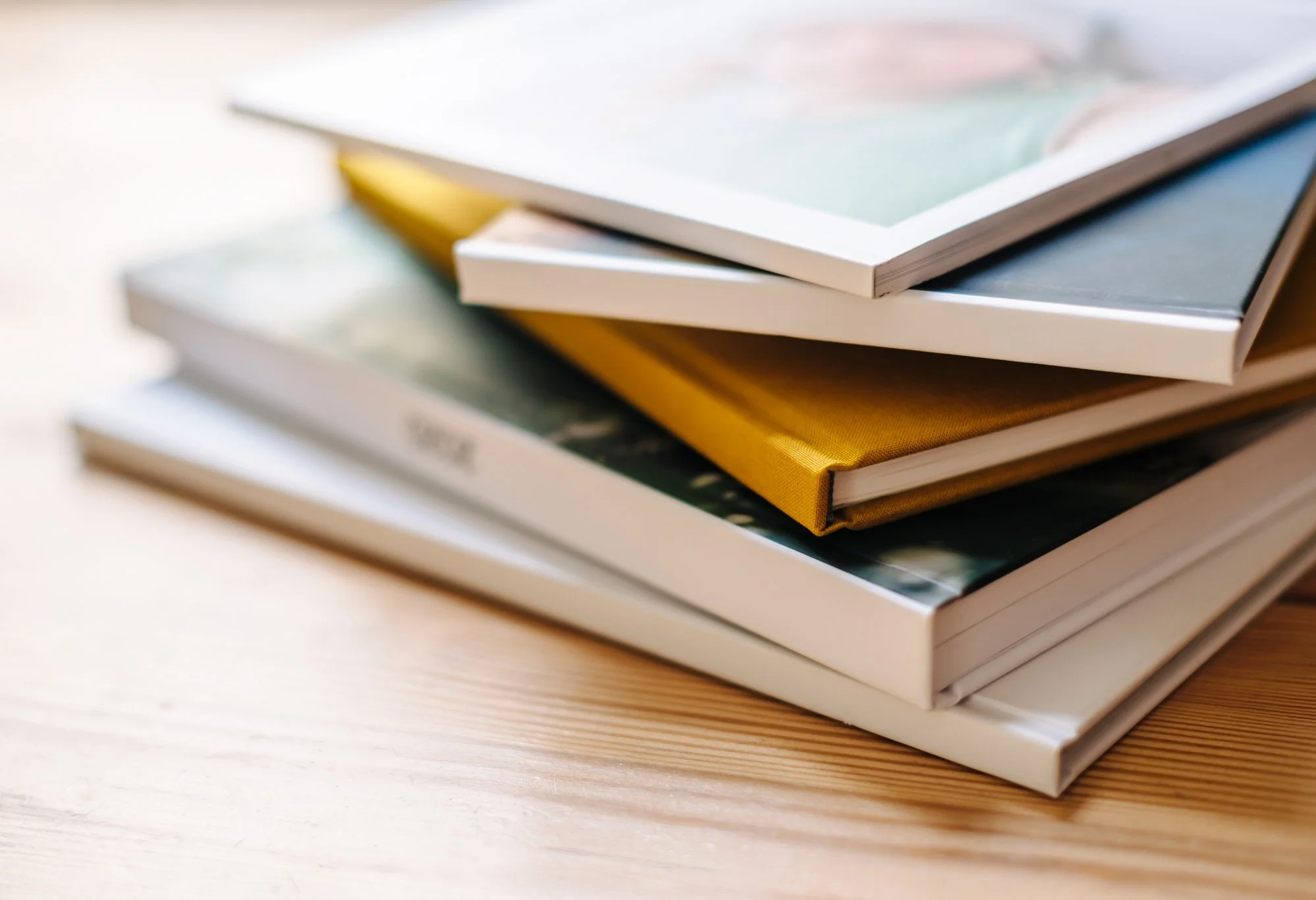 Fünf verschiedene Fotobücher liegen übereinander gestapelt.