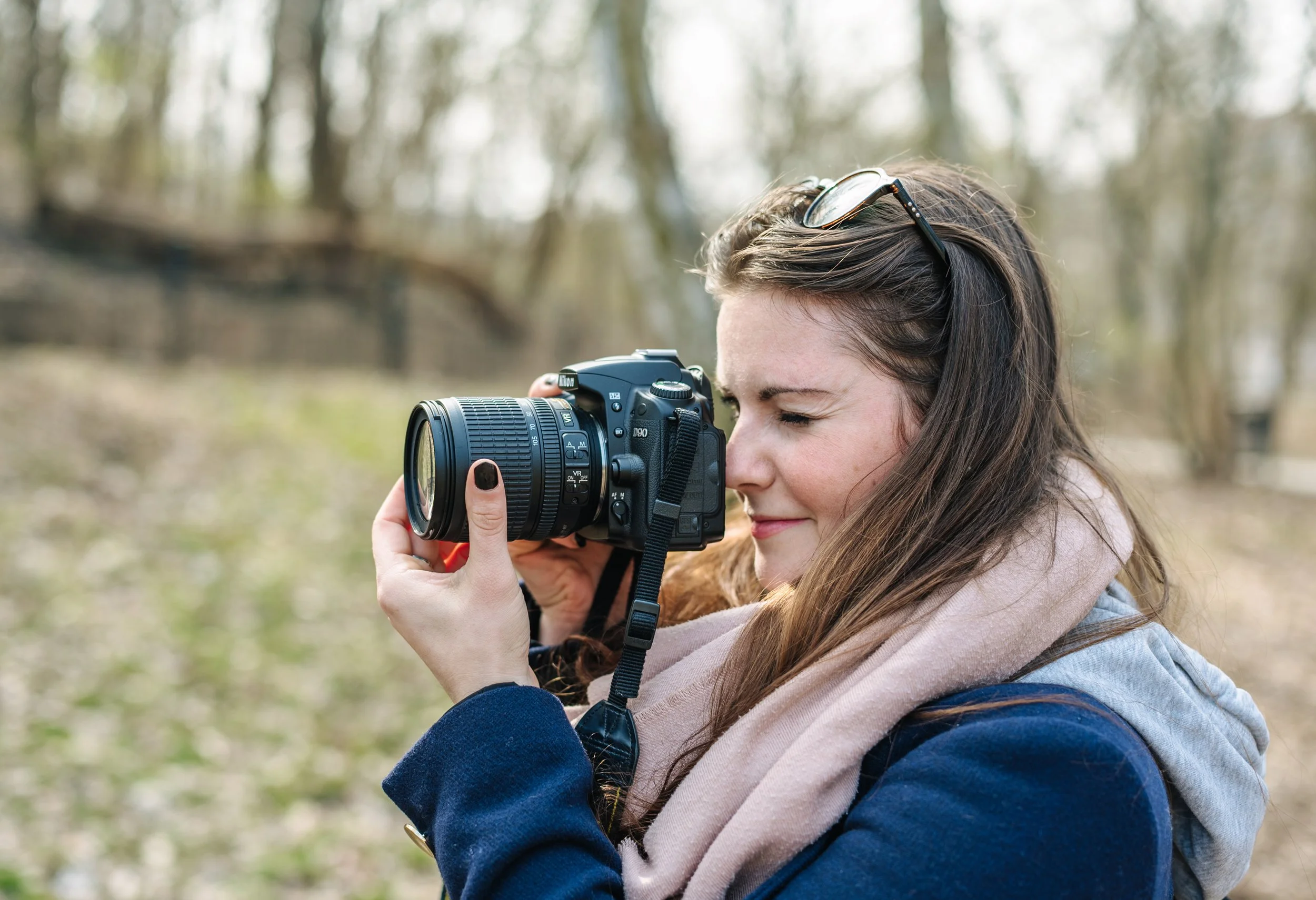 Eine Mama fotografiert mit einer digitalen Spiegelreflexkamera im Herbst.